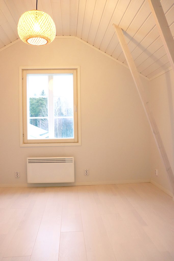 Valmiin ullakkoremontin toisen päädyn lastenhuone.